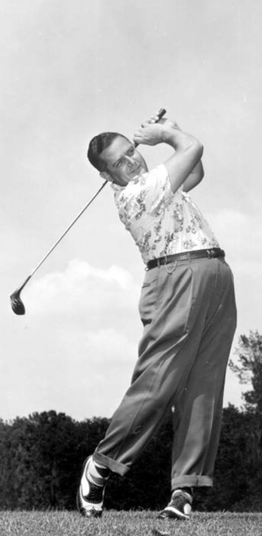 a golfer takes a swing